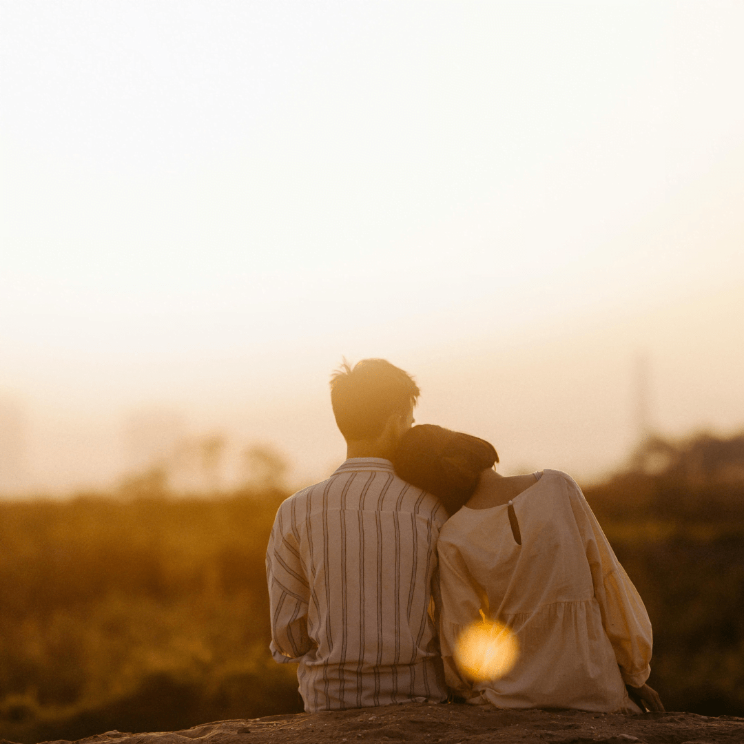 How to Balance Personal Goals While in a Relationship - couple sitting watching the sunset