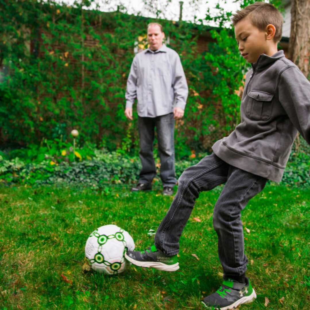 dad and son playing soccer -activities for Father's Day