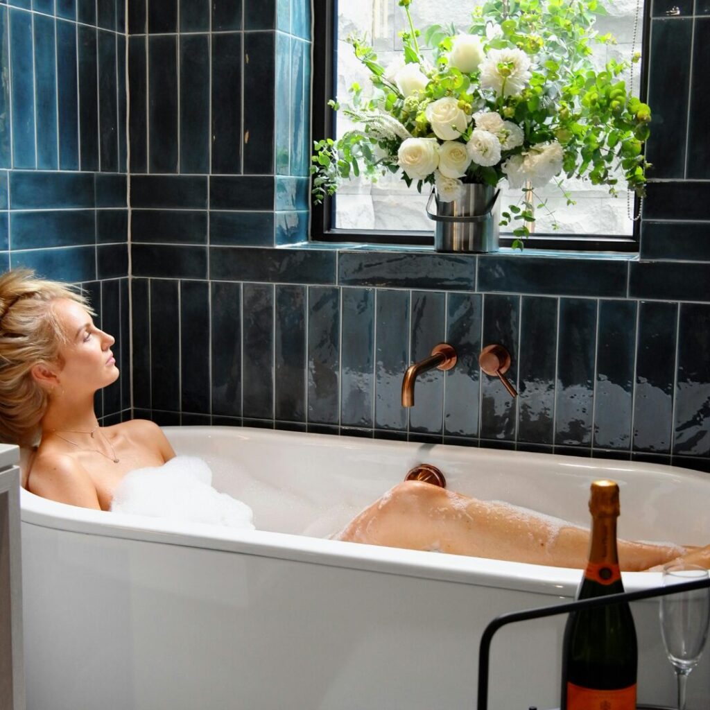 woman in a bath with a bottle of wine and flowers -How to Recover and Move On After a Breakup 5 ESSENTIAL STEPS