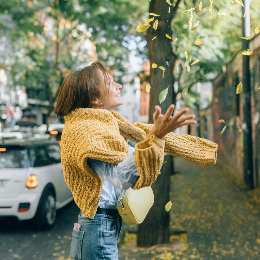 girl catching falling leaves in the fall -92 Fall Quotes About the Beautiful Autumn Season